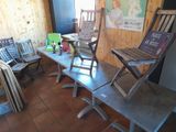 several chairs and a table in a room with a poster on the wall