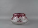 a small glass vase with a red design on it