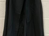 a black jacket hanging up against a white brick wall