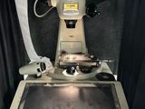 une machine posée sur une table, à côté d'un rouleau de papier toilette