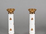 pair of white and gold candlesticks with floral decoration