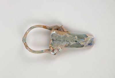 une bague en argent sertie d'une pierre, posée sur une surface blanche