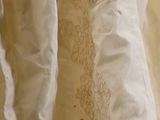 a close up of a wedding dress hanging on a hanger