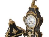 une horloge noire et dorée surmontée d'un drapeau