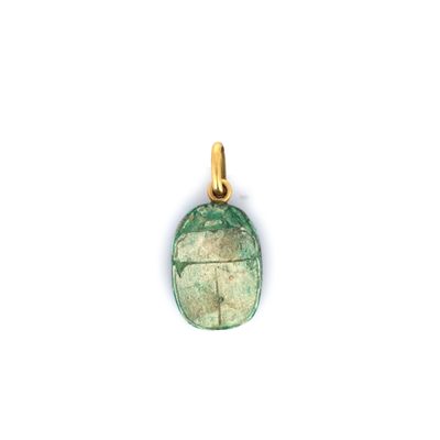 un pendentif en pierre verte muni d'une bélière plaquée or, sur fond blanc