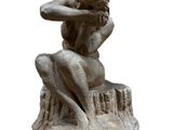 statue of a woman sitting on a rock with her hands on her head