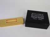 une image représentant une boîte noire avec une étiquette dorée et une boîte noire avec une étiquette dorée