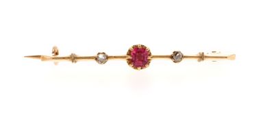 a close up of a red stone and gold bar broochle