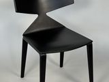 La chaise est en bois et son assise est noire.