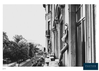 black and white photograph of a woman leaning against a building