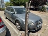 a silver car parked in a parking lot next to a tree