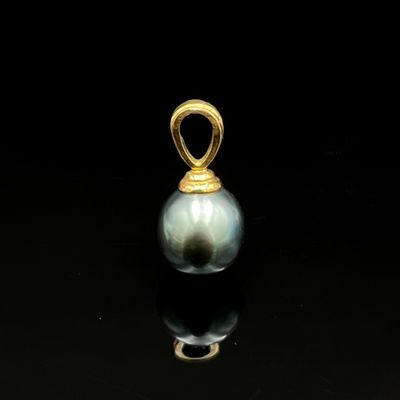 un gros plan d'un pendentif en perle sur une surface noire