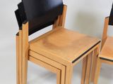 two wooden chairs and a small table on a white background