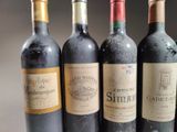 three bottles of red wine are lined up on a table