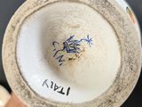 a close up of a white vase with a blue bird on it