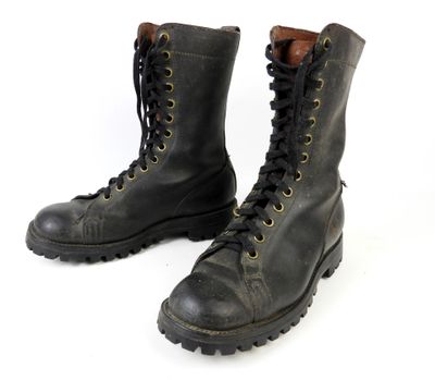 une paire de bottes en cuir noir à lacets sur fond blanc