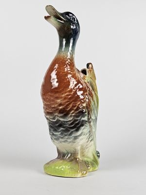 un petit canard en céramique posé sur une table