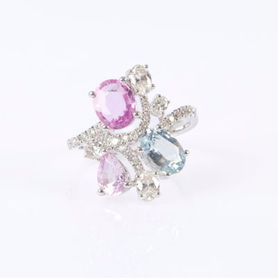 a close up of a ring with pink, blue and white stones