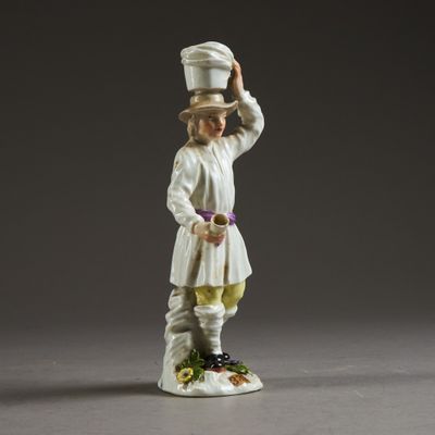 porcelain figurine of a man with a hat on top of his head
