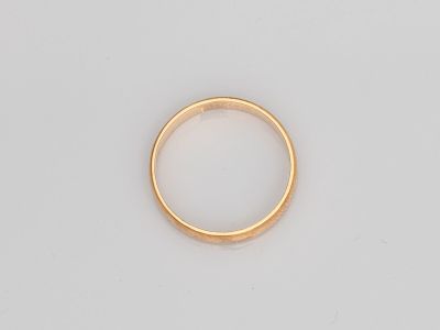 gros plan d'une bague en or sur une surface blanche
