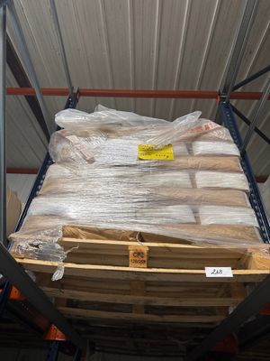 une palette sur laquelle est posé un matelas, dans un entrepôt