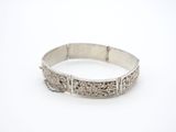 gros plan d'un bracelet en argent sur une surface blanche