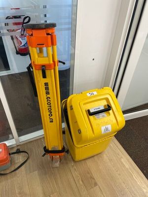 une valise jaune et un trépied jaune posés l'un à côté de l'autre