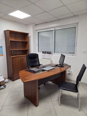 un bureau avec un ordinateur portable et une chaise dans une pièce