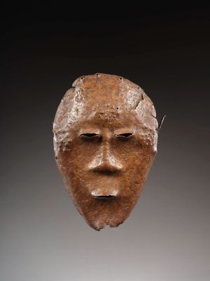 un gros plan sur une sculpture représentant un visage posée sur une table