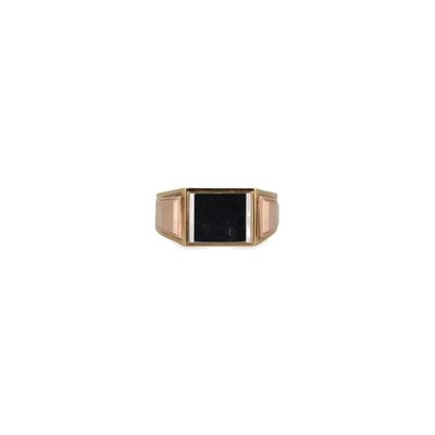 une bague en or avec une pierre noire au centre