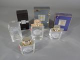 four small bottles of perfume sitting next to each other on a table