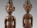 deux figurines en bois représentant deux hommes coiffés d'un chapeau