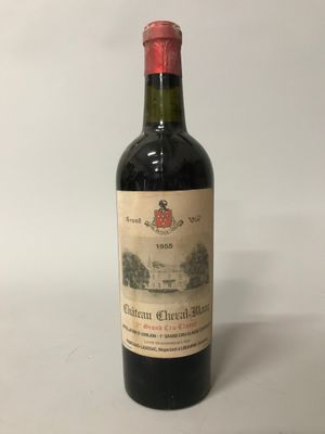 une vieille bouteille de vin posée sur une table blanche