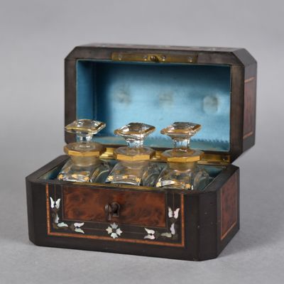 a wooden box with four glass jars inside of it