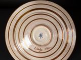 a brown and white plate with a blue design on it