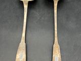 pair of antique wooden spoons on a black background