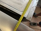 someone is measuring the width of a metal pan with a tape