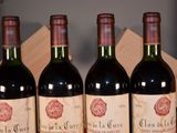three bottles of red wine sitting on a table next to a wooden box