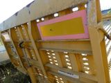 a close up of a yellow rail with a pink sign on it