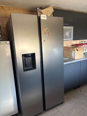 several stainless steel refrigerators and freezers are in a kitchen