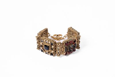 gros plan d'un bracelet en or sur fond blanc