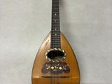 une vieille guitare en bois accrochée à un mur sur fond blanc