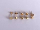 three pairs of gold plated stud earrings on a white surface