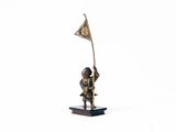 figurine d'un homme tenant un drapeau sur une base en bois