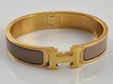 bracelet orné d'incrustations d'émail doré et marron sur un fond blanc
