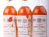 trois bouteilles de vin posées les unes à côté des autres sur une surface blanche