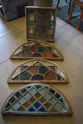three pieces of stained glass sit on a table next to a vase