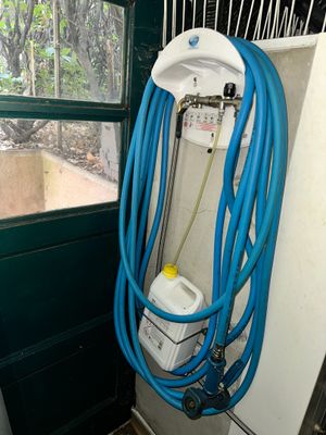a blue hose attached to a wall next to a window