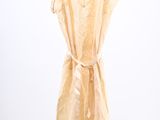 beige dress hanging on a hanger against a white wall