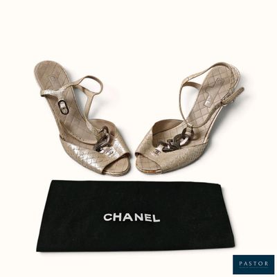 des chaussures Chanel et un sac noir posés sur une surface blanche